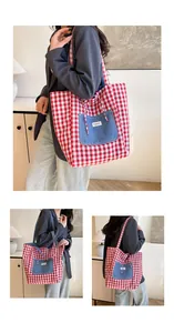 Detail of red checkered canvas tote bag with a blue denim pocket and shoulder strap
