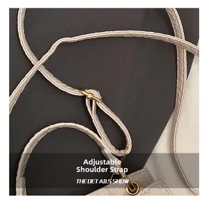 Détail de la bandoulière réglable en cuir avec boucle dorée sur sac blanc effet crocodile