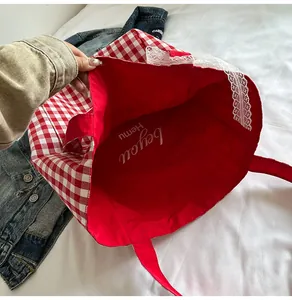 Detail of red gingham tote bag with lace trim showing the spacious red interior lining