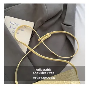 Détails de la bandoulière réglable et texture tressée sur un sac seau jaune
