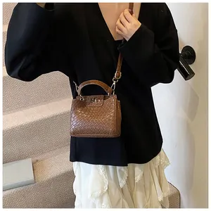 Sac à main vintage marron texturé avec fermoir rotatif et bandoulière réglable chic