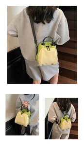 Minimalist lime green and cream nylon mini bag shown worn crossbody by a model.