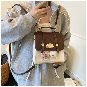 Détail d'un sac à dos contrasté avec fenêtre PVC et peluches à l'intérieur