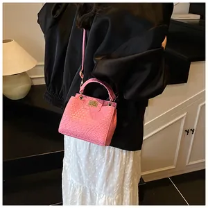 Vue détaillée du sac rose texture crocodile avec fermoir doré et bandoulière fine