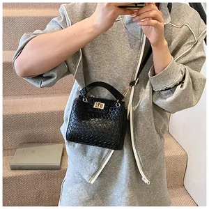 Détail du sac noir motif crocodile avec fermoir doré et bandoulière amovible