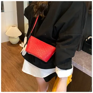Détail du sac seau en cuir tressé rouge avec motif intrecciato et fine bandoulière