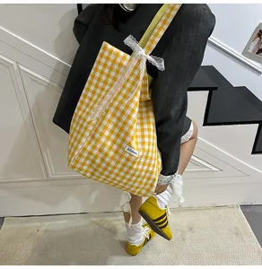 Detail of yellow gingham tote bag featuring delicate lace edges and a sweet ribbon bow
