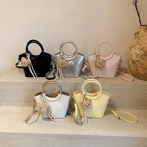Chic trapezoid bucket bags in five colors with cute bear charms and crossbody straps
