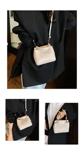 Détails du sac à main crème avec texture crocodile, fermoir doré et bandoulière amovible