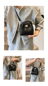 Détail du sac à main noir à motif croco avec fermoir doré et poignée supérieure