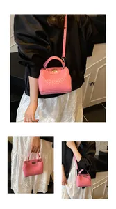 Détail d'un sac rose avec gaufrage crocodile, fermoir doré et bandoulière amovible