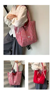 Detail of red and white checkered canvas tote bag with lace trim and embroidered lettering