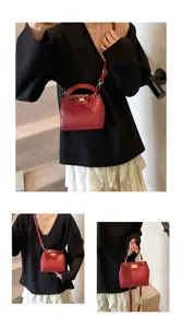 Détail du petit sac bandoulière rouge matelassé avec fermoir doré et texture tissée