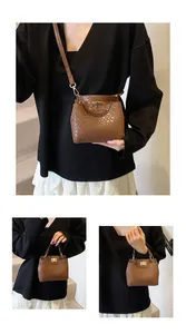 Vue détaillée du sac en cuir marron à motif crocodile avec fermoir rotatif doré brillant