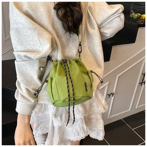 Detail der grünen Kordelzug-Beuteltasche mit schwarzer Netztasche und Nylonstruktur
