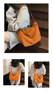 Close-up of bright orange large tote bag with adjustable wide strap and nylon texture