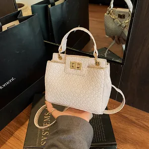 Sac bandoulière blanc tressé avec fermoir doré et poignée au style urbain minimaliste