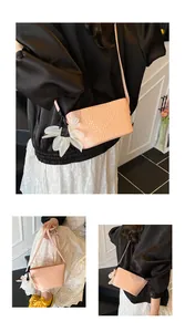 Détail du sac seau rose tressé avec breloque fleur en résille blanche et fine bandoulière