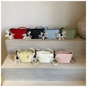 Détail de mini sacs seaux tressés en sept couleurs avec breloques de fleurs en tulle