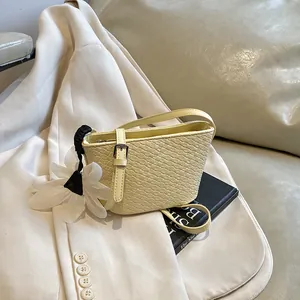 Sac seau tissé jaune clair orné d'une breloque fleur blanche et d'un ruban en soie