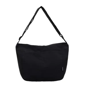 Minimalist black large capacity canvas tote bag with adjustable strap and front pocket