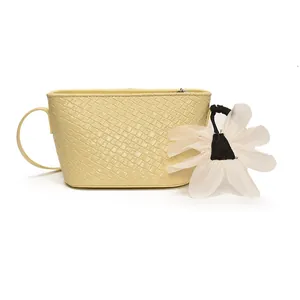 Sac seau jaune pâle tressé à la mode avec breloque fleurie et bandoulière fine