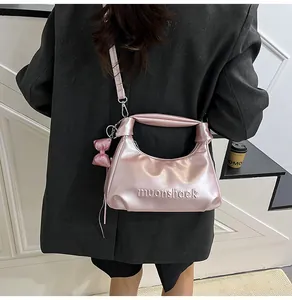 Sac bandoulière rose métallisé avec inscription muonshaek et poignée nouée élégante