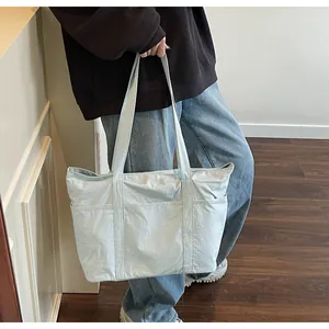Close-up of light blue minimalist tote bag with three front pockets and crinkled texture