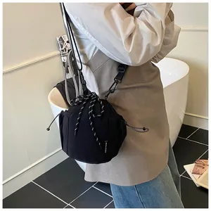 Detail der schwarzen Nylon-Beuteltasche mit Kordelzug und gewebtem Markenlabel