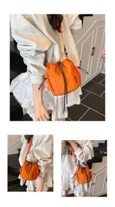 Detail der leuchtend orangefarbenen Beuteltasche mit Netztaschen und Schultergurt