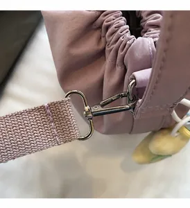 Detail der lila Nylontasche mit Kordelzug, Silberhaken und kleinem Entenanhänger