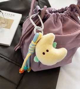 Detail der lavendelfarbenen Nylon-Beuteltasche mit Kordelzug und buntem Mond-Plüschanhänger