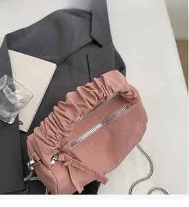Détail du sac oreiller en nylon rose avec poignée froncée et double zip métallique