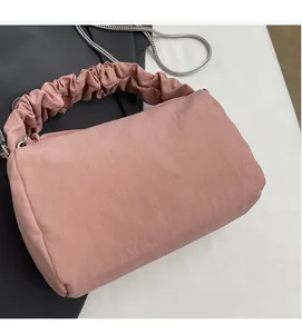Détail du sac à main plissé rose avec poignée nuage et fine bandoulière en chaîne argentée