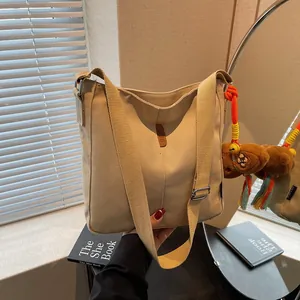 Borsa a secchiello in tela beige con logo OZBG e ciondolo a forma di orsetto arancione