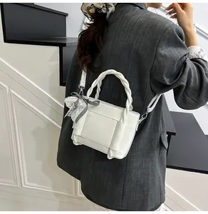 Détail du sac seau en PU blanc avec poignée tressée et charmant nœud en dentelle