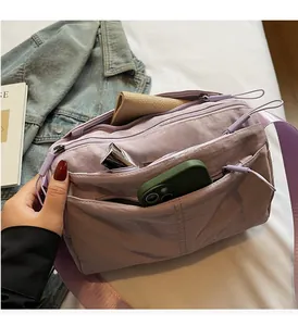 Detail of light purple waterproof nylon crossbody bag with multiple zipper compartments