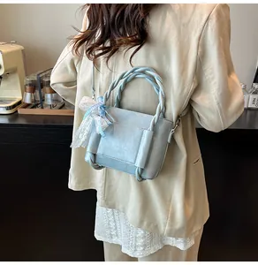 Sac seau bleu clair avec poignée torsadée et détail de nœud en ruban de dentelle
