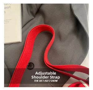 Detail of adjustable red woven nylon shoulder strap on canvas crescent dumpling bag