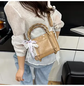 Détail de la poignée tissée avec ruban écossais violet sur sac seau camel texturé