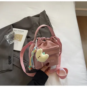Detail of pink nylon bucket bag with drawstring, Chao Nv Hai print and moon plush charm
