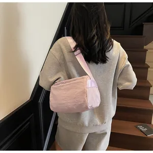 Detailed view of the purple nylon crossbody bag worn by a model on stairs