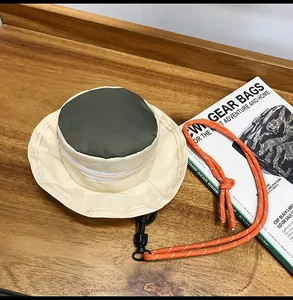 Detailansicht eines beigen und dunkelgrünen Hutes Mini-Beutel mit orangefarbener Kordel