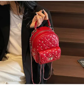 Macro view of red quilted leather mini backpack with sparkling rhinestone embellishments