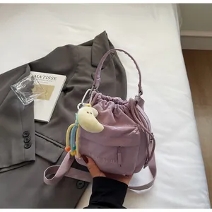 Detail of lavender nylon bucket bag with drawstring closure and plush moon charm
