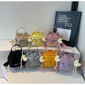 Close-up of nylon drawstring bucket bags in multiple colors with cute plush pendants