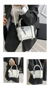 Détail du mini sac seau blanc avec poignée torsadée et nœud décoratif en dentelle