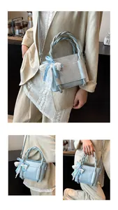 Détail des poignées tressées et du nœud en dentelle sur le sac carré bleu clair élégant