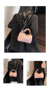 Détail du sac à main rose avec poignée froncée et bandoulière chaîne amovible
