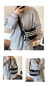 Detail of black canvas crescent bag featuring sporty white stripes and wide shoulder strap